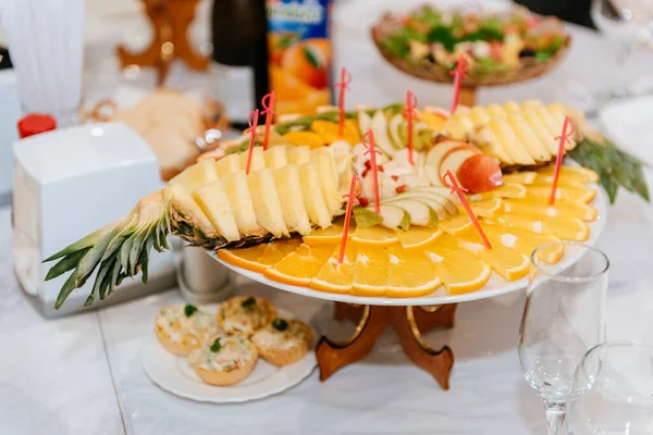 Блюдо с ананасом и оранжевым нарезкой. Фруктовая тарелка с прекрасно вырезанными апельсинами и ананасами. — стоковое фото