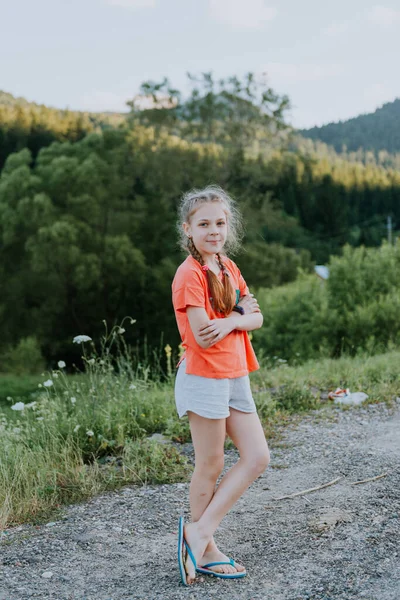 Egy napsütéses napon egy gyönyörű fiatal turista lány portréja, hátizsákkal, divatnővel, sétál az erdőben, a fák hátterében. Koncepció: kikapcsolódás, gyönyörű kilátás, sport, utazás. — Stock Fotó