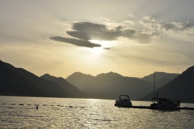 Adanın yakınındaki yatlar denizin üzerindeki altın gün doğumunda. Günbatımına doğru yelken açıyorum. Günbatımı denizinde yatların silueti.