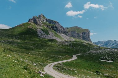 Durmitor dağları, Ulusal Park, Akdeniz, Karadağ, Balkanlar ve Avrupa 'da günbatımı manzarası. Sedlo Geçidi 'nden parlak yaz manzarası. Instagram fotoğrafı. Dağlardaki evin yanındaki yol.