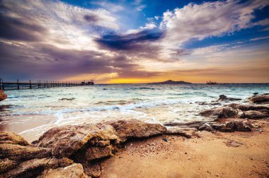 Harika güneş Kızıl Deniz plaj gün batımında bir lüks otel. Sharm El Sheikh, Sinai, Mısır. Dağlar ve büyük bir dalga ile altın günbatımı.