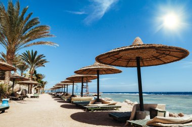 Harika güneş Kızıl Deniz plaj gün batımında bir lüks otel. Sharm El Sheikh, Sinai, Mısır. Dağlar ve büyük bir dalga ile altın günbatımı.