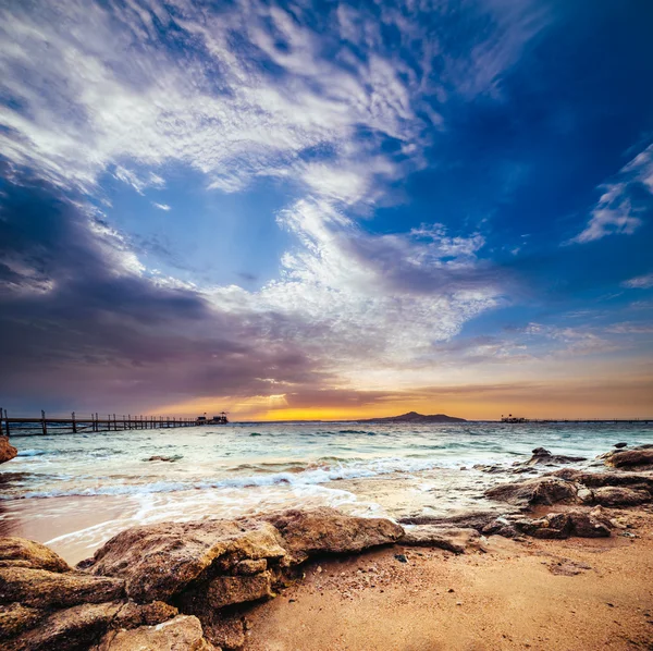 Wonderful solar Red Sea beach at a luxury hotel, at sunset. Sharm El Sheikh, Sinai, Egypt. Gold sunset with mountains and big wave. — Stock Photo, Image