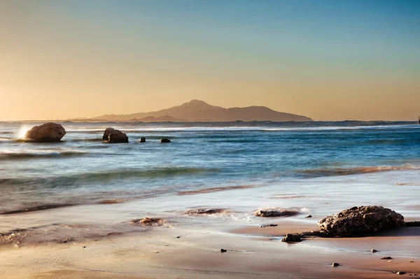 Wonderful solar Red Sea beach at a luxury hotel, at sunset. Sharm El Sheikh, Sinai, Egypt. Gold sunset with mountains and big wave. — Stock Photo, Image