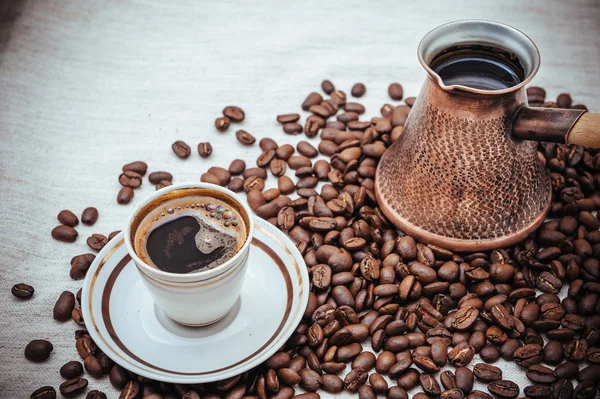 Coffee turk and roasted beans on burlap background.