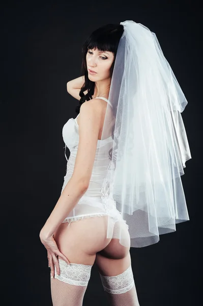 Sexy bella sposa nuda con velo in lingerie erotica bianca su uno sfondo nero. ritratto di bellezza della donna — Foto Stock