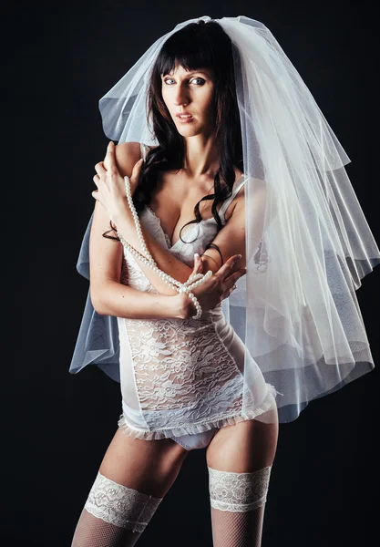 Sexy bella sposa nuda con velo in lingerie erotica bianca su uno sfondo nero. ritratto di bellezza della donna — Foto Stock