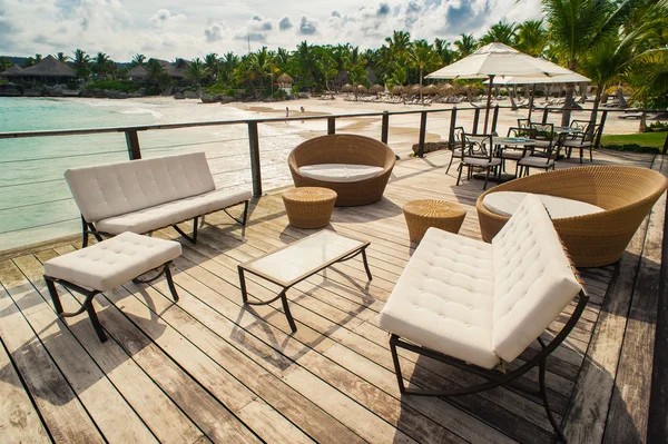 Outdoor restaurant at the seashore. Table setting in tropical Summer Beach Cafe, ocean and sky. Dominican Republic, Seychelles, Caribbean, Bahamas. Relaxing on remote Paradise beach. — Stock Photo, Image