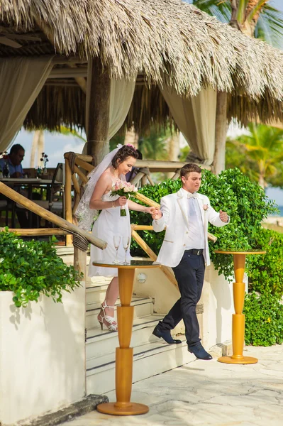 Fiatal, szerelmes pár a trópusi tengeri háttere - a strandon esküvői. — Stock Fotó