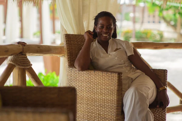 Wanita kulit hitam berseragam hotel. Senyum bergaya indah resepsionis menyerahkan di pantai . — Stok Foto