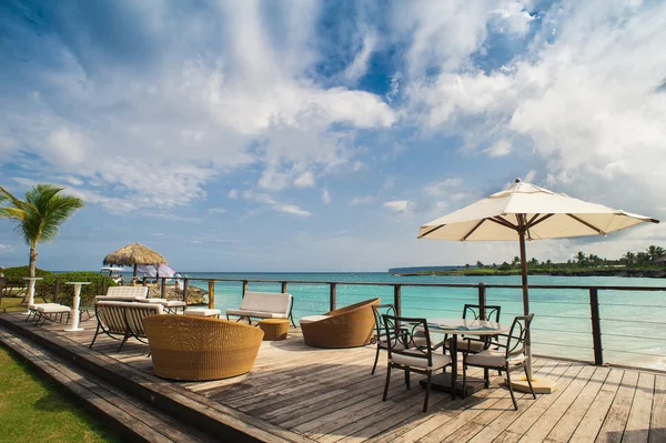 Restoran terbuka di tepi pantai. Pengaturan meja di tropis Summer Beach Cafe, laut dan langit. Republik Dominika, Seychelles, Karibia, Bahama. Relaksasi di pantai terpencil Paradise . Stok Gambar