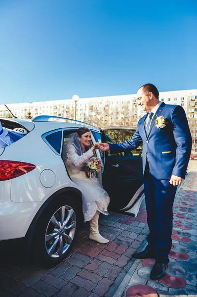 Bride and groom near vintage decorated car on wedding day. — Stock Photo, Image