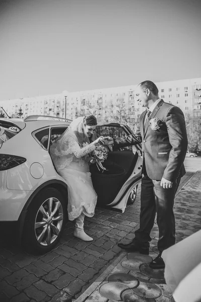 Жених и невеста возле старинного украшенного автомобиля в день свадьбы . — стоковое фото
