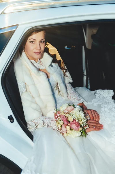 Close-up portrait of pretty shy bride in a car window — Stock Photo, Image