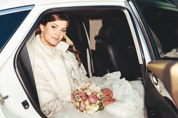 Close-up portrait of pretty shy bride in a car window — Stock Photo, Image