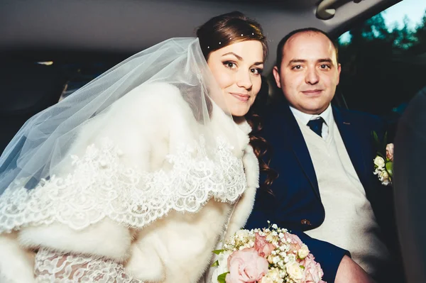 Portret van gelukkige bruid en bruidegom in de auto. — Stockfoto