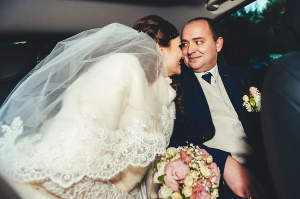 Portret van gelukkige bruid en bruidegom in de auto. — Stockfoto