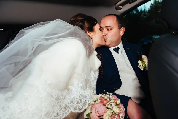 Portret van gelukkige bruid en bruidegom in de auto. — Stockfoto