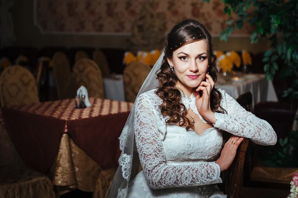 Linda noiva loira em vestido de noiva no interior de luxo com jóias de diamante posando em casa e esperando o noivo . — Fotografia de Stock