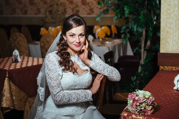 Splendida sposa bionda in abito da sposa su interni di lusso con gioielli di diamanti in posa a casa e in attesa di sposo . — Foto Stock