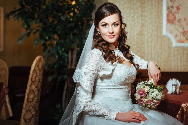 Splendida sposa bionda in abito da sposa su interni di lusso con gioielli di diamanti in posa a casa e in attesa di sposo . — Foto Stock