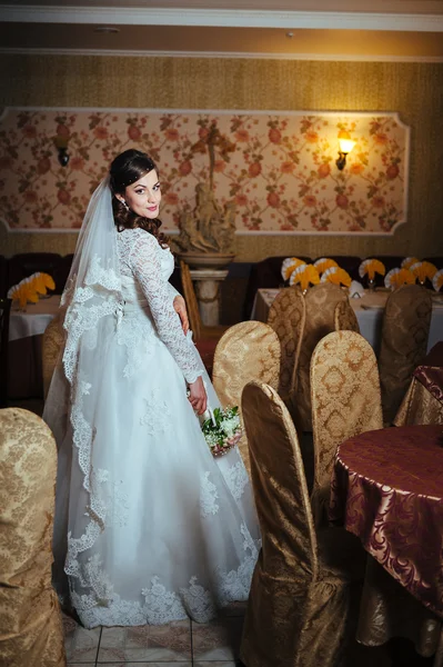 Splendida sposa bionda in abito da sposa su interni di lusso con gioielli di diamanti in posa a casa e in attesa di sposo . — Foto Stock