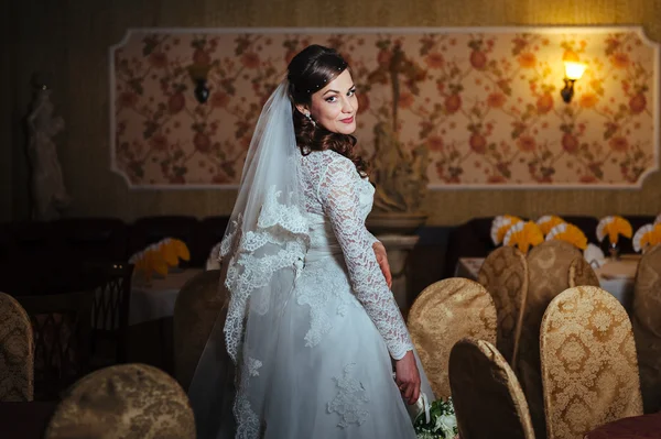 Blondýna nádherná nevěsta ve svatebních šatech na luxusní interiér s bižutérie působícím doma a čeká na ženicha. — Stock fotografie