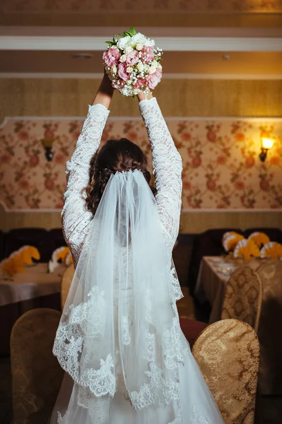 Hermosa novia rubia en vestido de novia en el interior de lujo con joyas de diamantes posando en casa y esperando al novio . — Foto de Stock