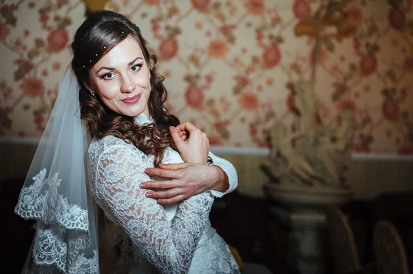 Linda noiva loira em vestido de noiva no interior de luxo com jóias de diamante posando em casa e esperando o noivo . — Fotografia de Stock