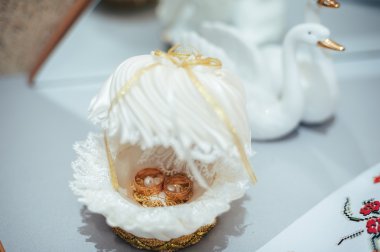 Altın alyanslar bir buket beyaz gülün üzerinde