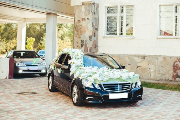 Schwarzes Hochzeitsauto mit weißen Rosen geschmückt — Stockfoto