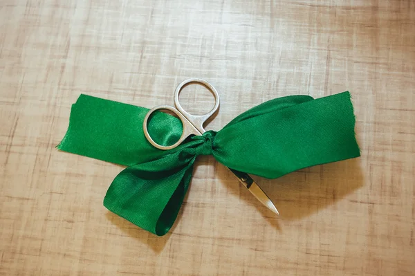 Scissors cut green silk ribbon — Stock Photo, Image