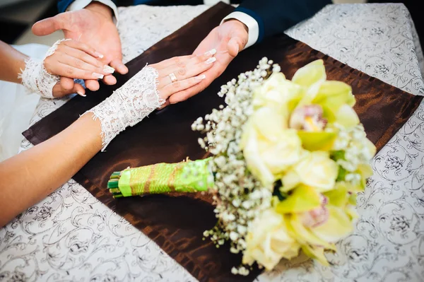 Una pareja amorosa sentada en un café el día de su boda. Ramo de flores — Foto de Stock