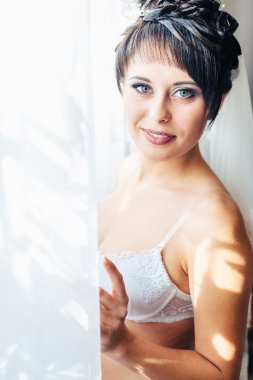 Striptiz çıplak gelin. Güzel kız beyaz iç çamaşırı düğün elbisesi ile oynamak. Neşeli kadın poz