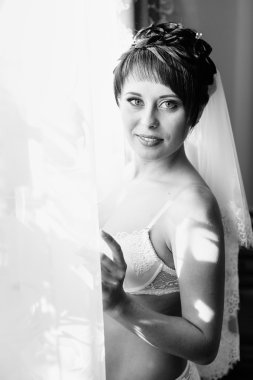 Striptiz çıplak gelin. Güzel kız beyaz iç çamaşırı düğün elbisesi ile oynamak. Neşeli kadın poz