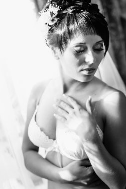 Striptiz çıplak gelin. Güzel kız beyaz iç çamaşırı düğün elbisesi ile oynamak. Neşeli kadın poz