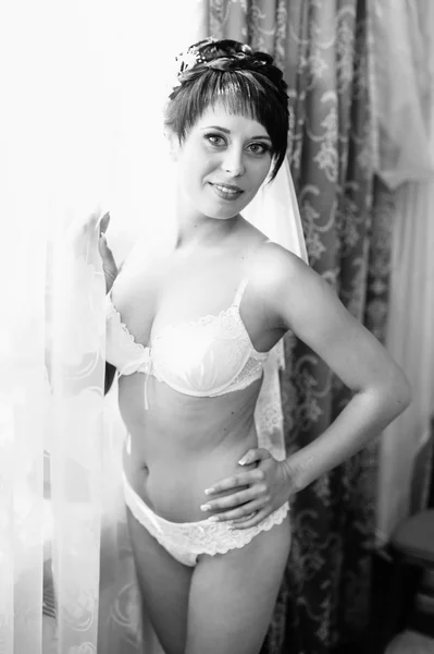 Mariée nue Striptease. Belle fille en lingerie blanche jouer avec sa robe de mariée. Jeune femme gaie posant — Photo