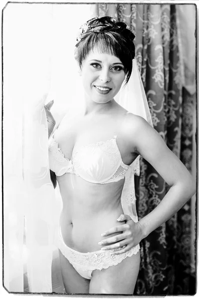 Sposa nuda Spogliarello. Bella ragazza in lingerie bianca giocare con il suo abito da sposa. Giovane donna allegra posa — Foto Stock