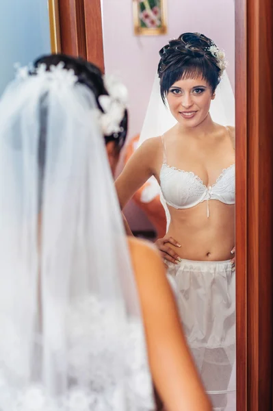 Sposa nuda Spogliarello. Bella ragazza in lingerie bianca giocare con il suo abito da sposa. Giovane donna allegra posa — Foto Stock