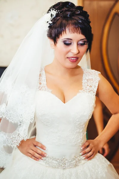 Sposa con orecchini in mano. Ritratto di una donna stupenda che si aggiusta l'orecchino. Momento di preparazione per il matrimonio . — Foto Stock