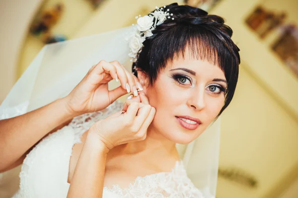 Νύφη εκμετάλλευση σκουλαρίκια. Προσωπογραφία πανέμορφο ρύθμιση της σκουλαρίκι. Στιγμή προετοιμασία για το γάμο. — Φωτογραφία Αρχείου