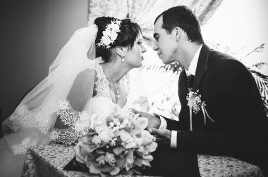 Sevgi dolu çift düğün gününde bir kafede oturuyor. Buket çiçek