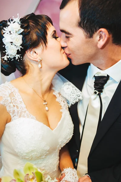 Junges Brautpaar küsst sich und genießt romantische Momente am Hochzeitstag — Stockfoto
