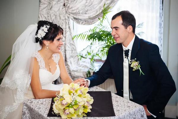 Casal amoroso sentado em um café no dia do casamento. Buquê de flores — Fotografia de Stock