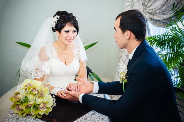 Casal amoroso sentado em um café no dia do casamento. Buquê de flores — Fotografia de Stock