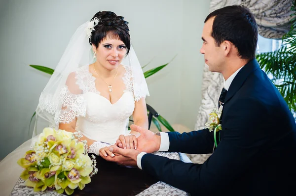 Casal amoroso sentado em um café no dia do casamento. Buquê de flores — Fotografia de Stock