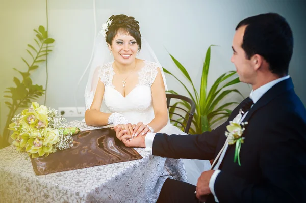 Una pareja amorosa sentada en un café el día de su boda. Ramo de flores — Foto de Stock