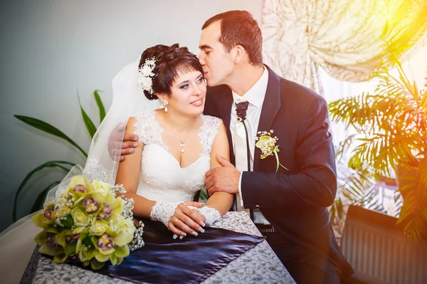 Casal amoroso sentado em um café no dia do casamento. Buquê de flores — Fotografia de Stock