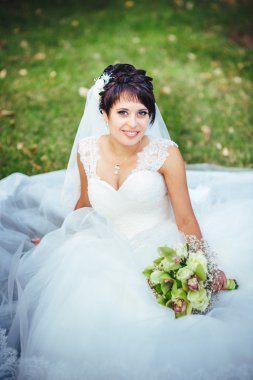 parlak buket elinde tutan güzel genç gelin portresi. düğün kutlama. doğa yeşil arka plan. açık havada parkta yalnız kadın