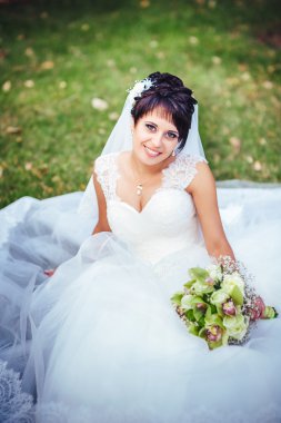 parlak buket elinde tutan güzel genç gelin portresi. düğün kutlama. doğa yeşil arka plan. açık havada parkta yalnız kadın